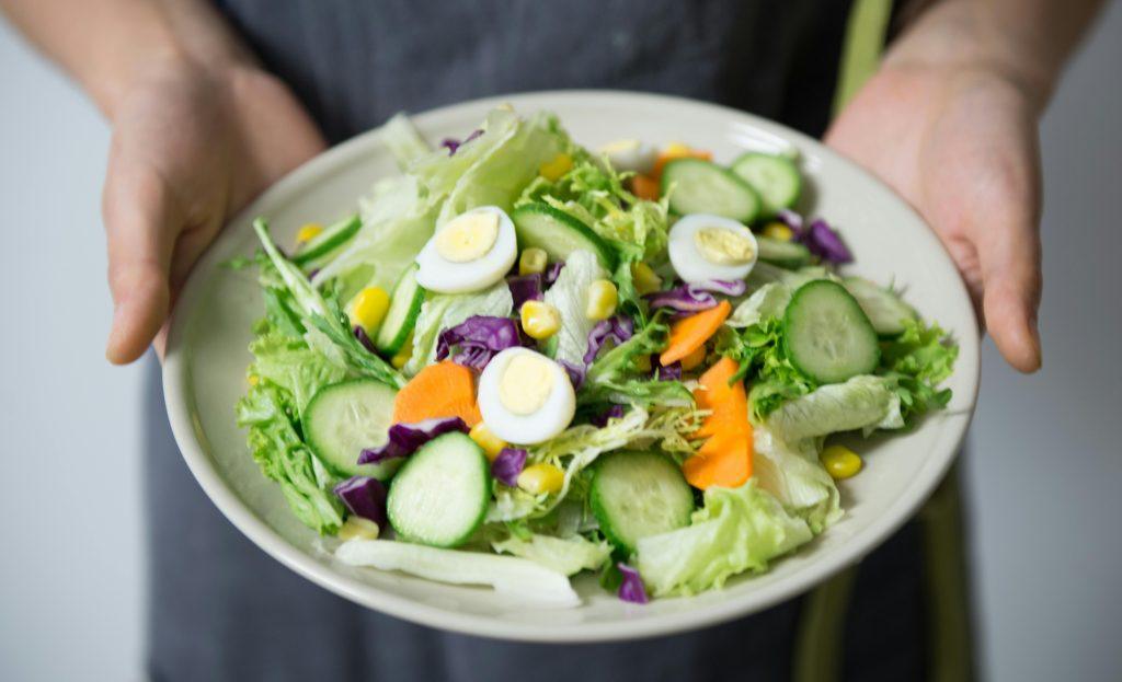 A person holding a salad