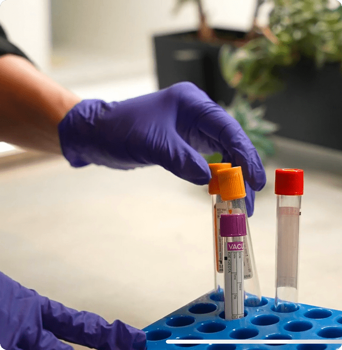 Medical professional handling blood sample collection tubes during laboratory testing at a medical clinic in Edina, Minnesota.