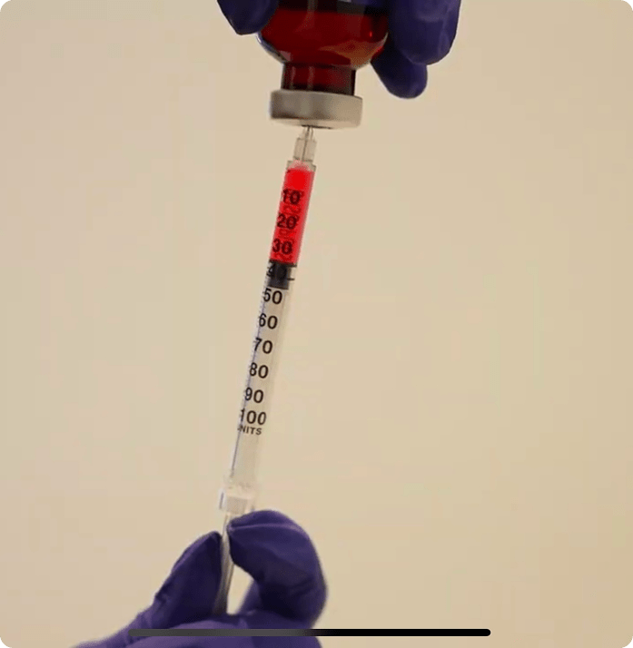 Medical professional drawing weight loss medication into a syringe from a vial during treatment preparation at a medical clinic in Edina, Minnesota.