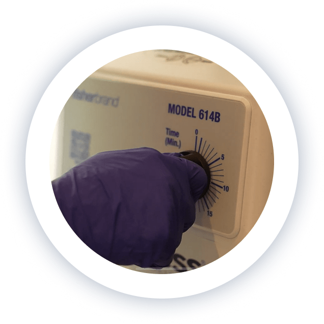 Gloved medical staff member operating lab equipment at Lite Medical Clinic as part of sterile medication preparation.