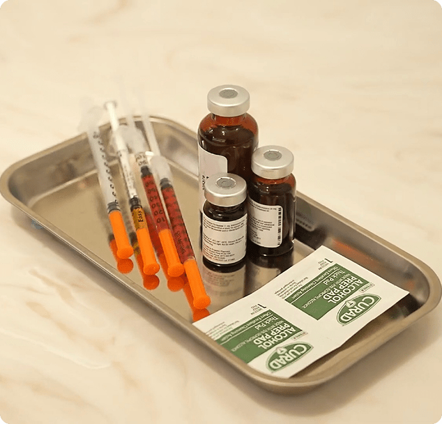 Sterile injection supplies on a medical tray at a medical clinic in Edina, Minnesota, including syringes, medication vials, and alcohol prep pads prepared for patient treatment.
