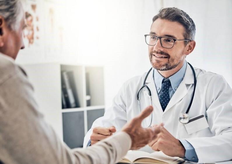 Male physician discussing testosterone therapy and body composition with middle-aged male patient in Bloomington clinic