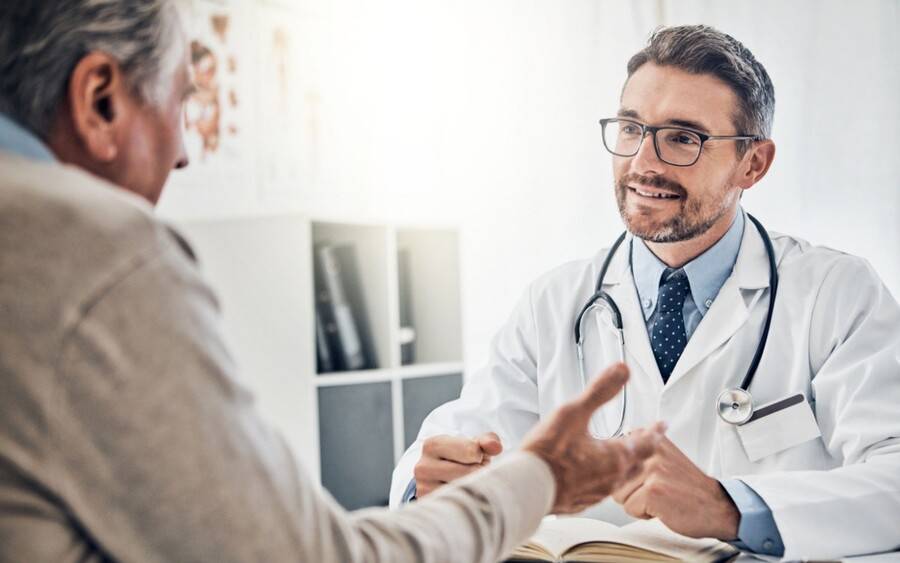 Male physician discussing testosterone therapy and body composition with middle-aged male patient in Eden Prairie clinic